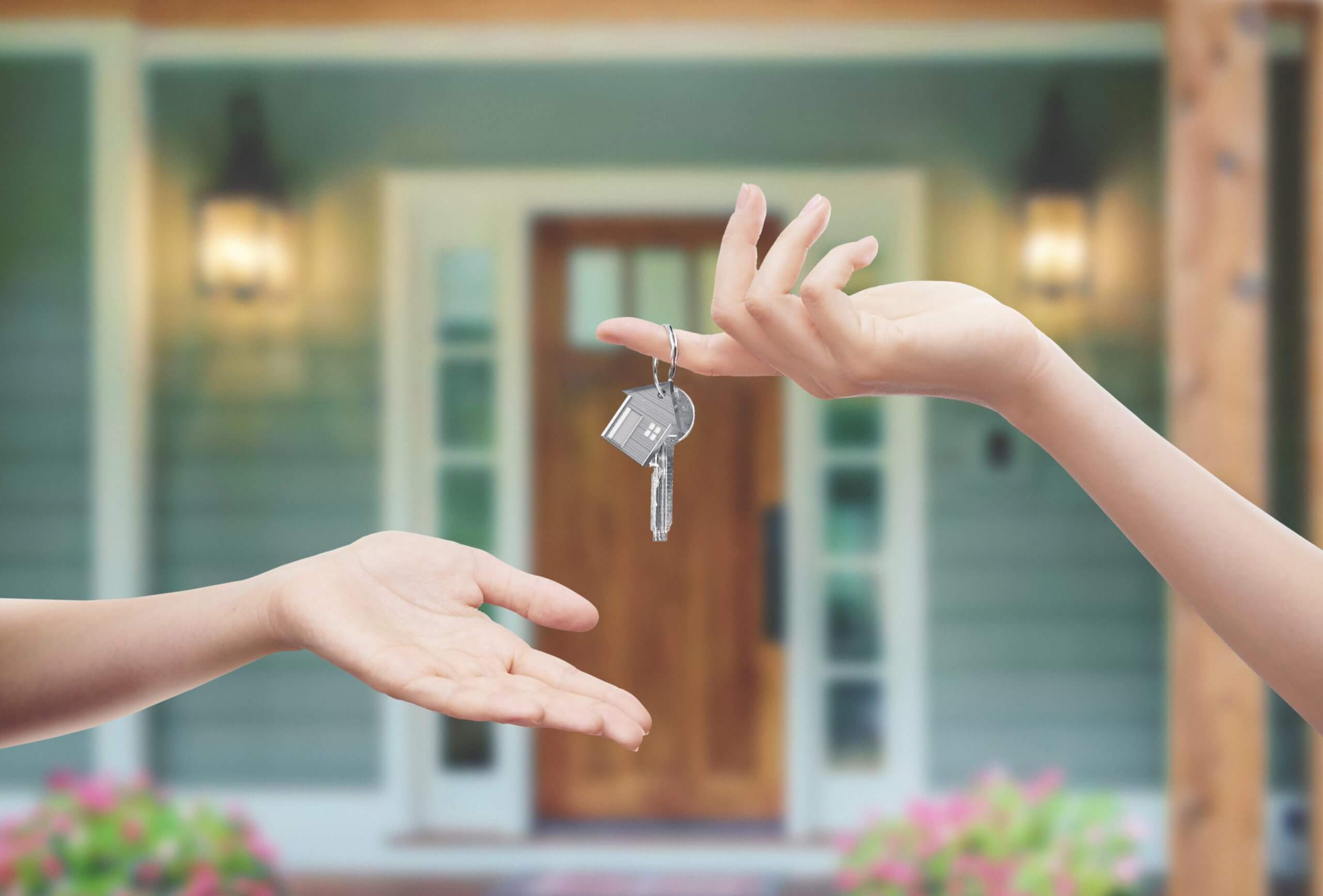 landlord hand giving keys to hand of renter | Value of Your Rental