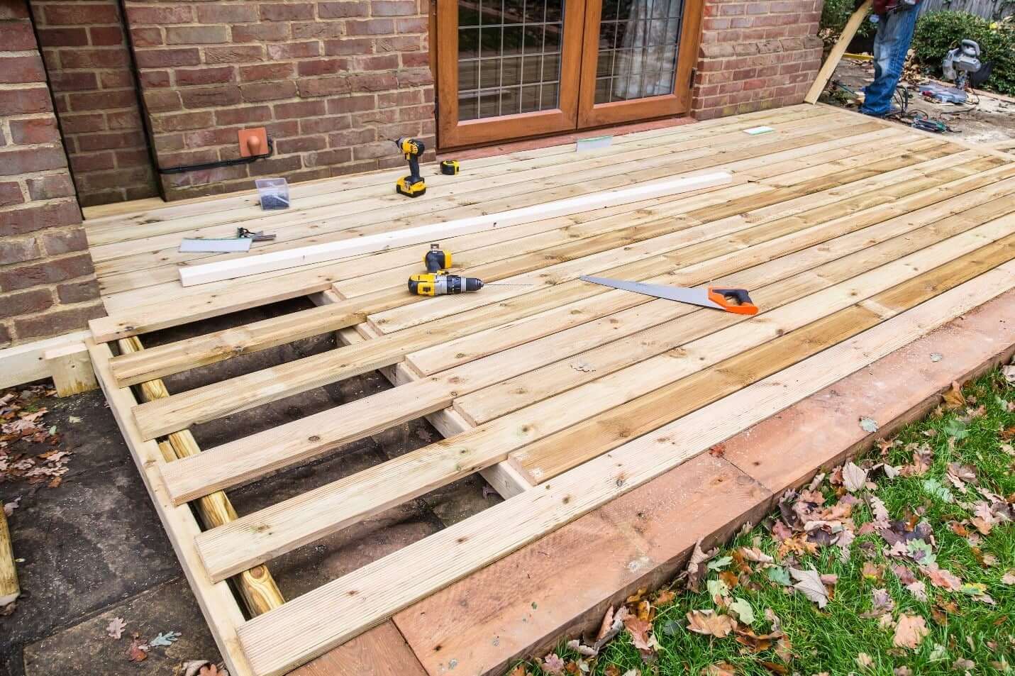 a deck in the process of being built on the side of a home
