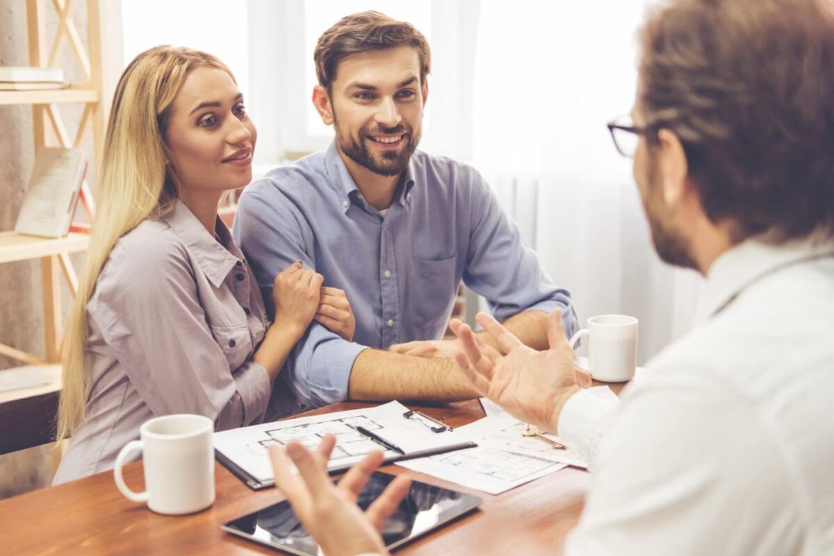 An attractive couple talks to a realtor about a rental property