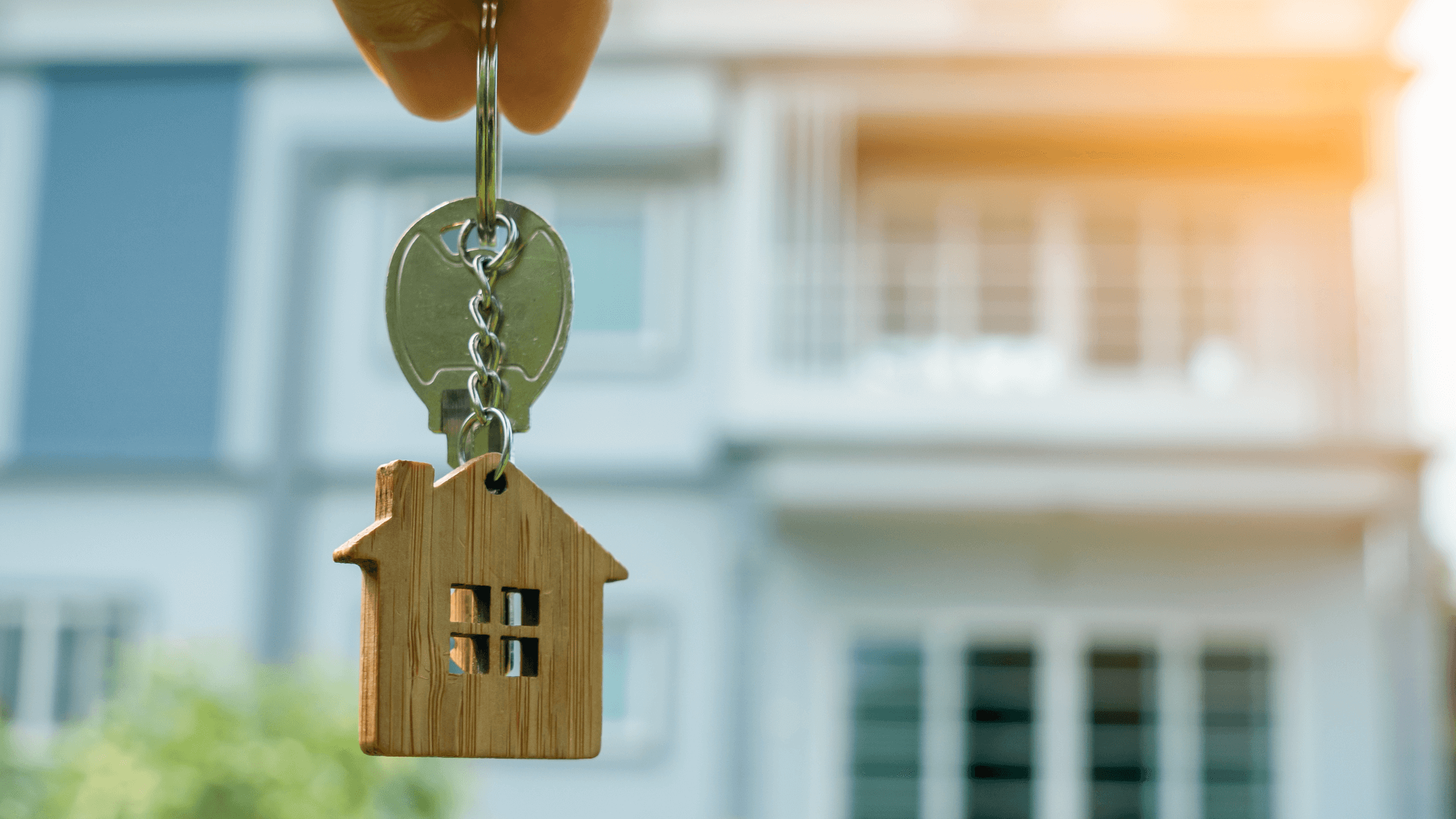 Person holding key to home with house keychain | Tucson Renters